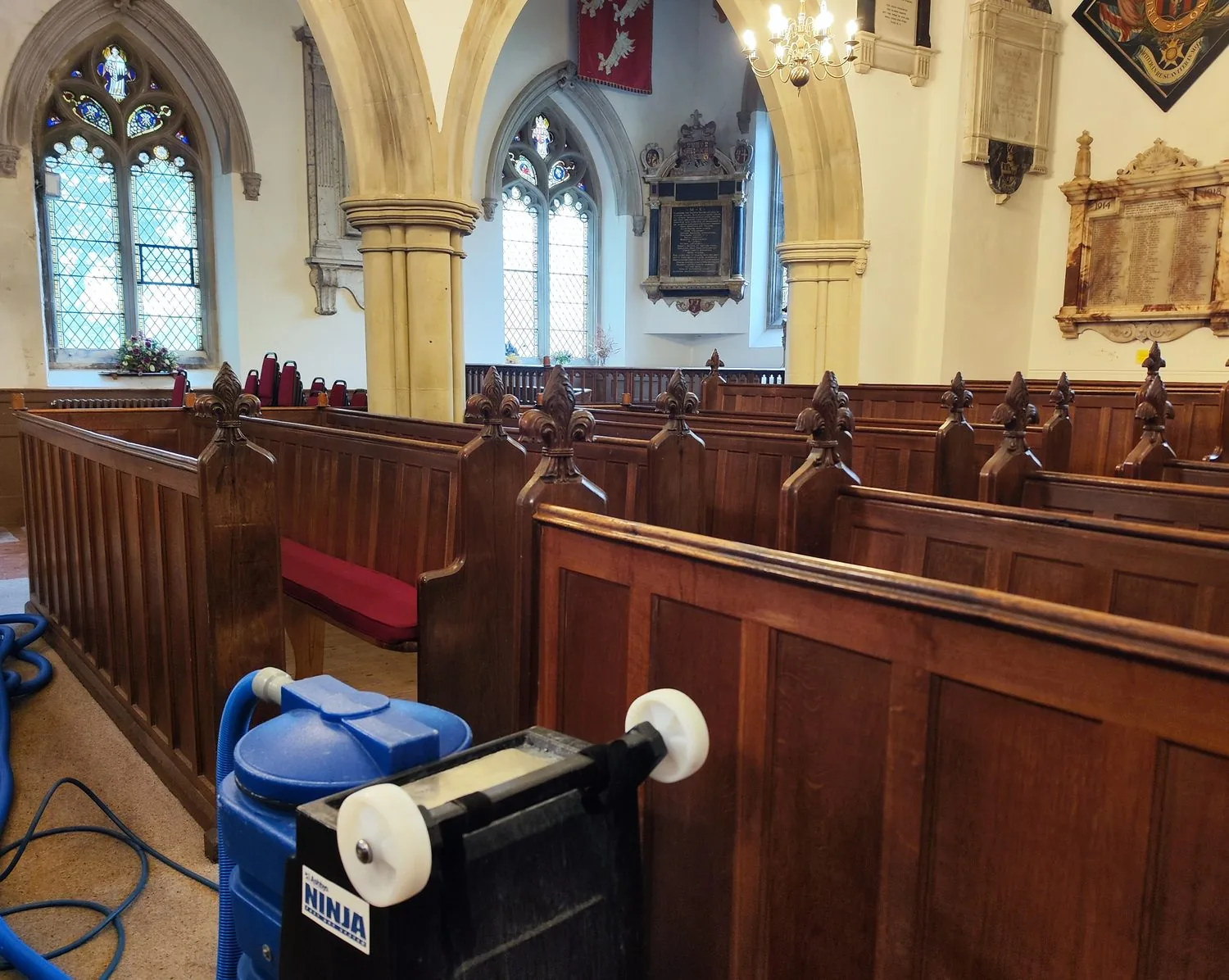 Extraction equipment set up between the pews during a church carpet clean