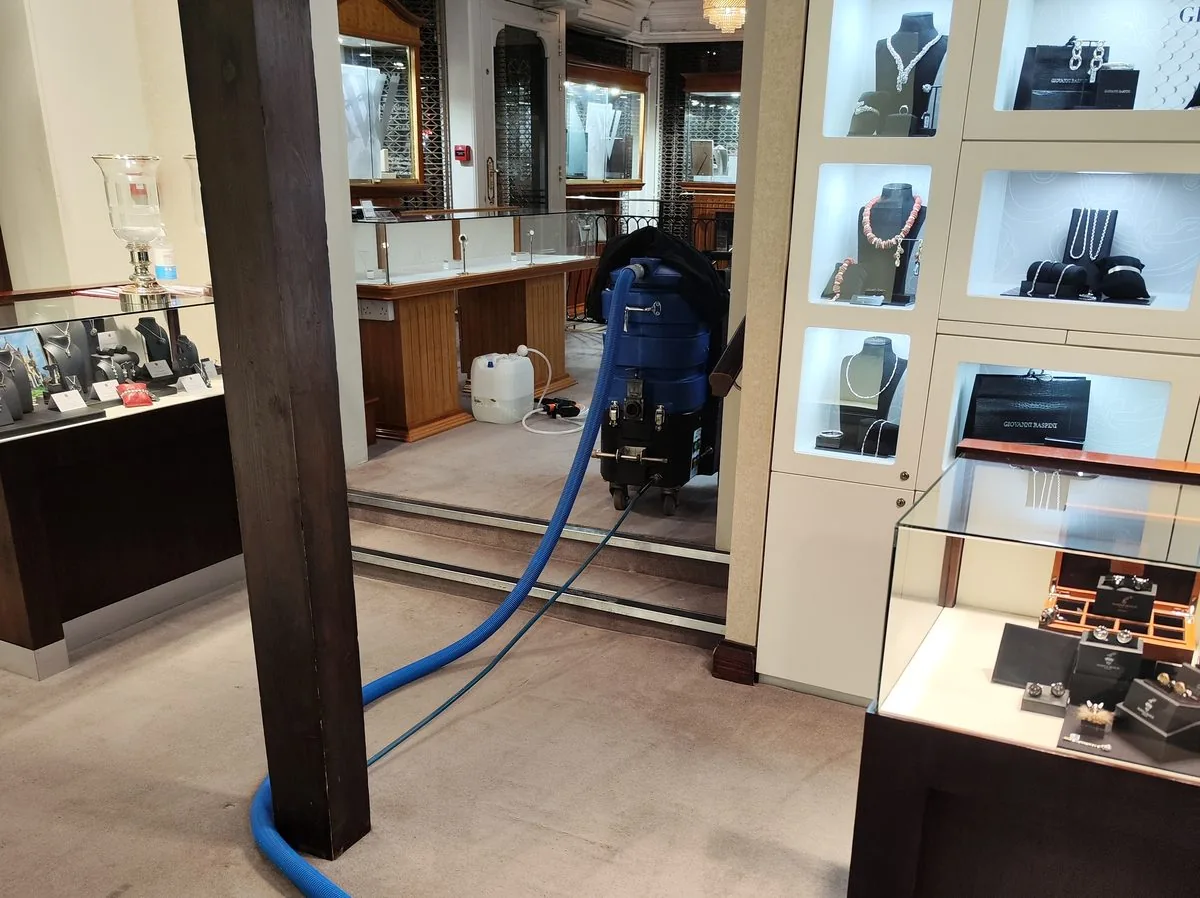 Carpet cleaning in progress between the display cases of a jewellery shop