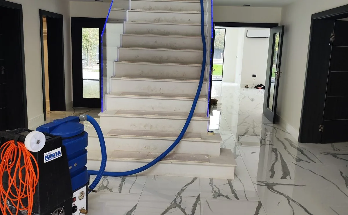 Capital Carpet Cleaners extraction machine and hoses set up on a marble hallway floor and staircase
